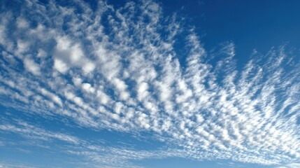 Blue sky with altocumulus clouds creating a textured cloudscape pattern.