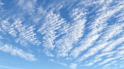 White cirrocumulus clouds fill a clear blue sky creating a textured pattern.
