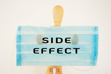 Man is holding a blue surgical mask with the words Side Effect written on it