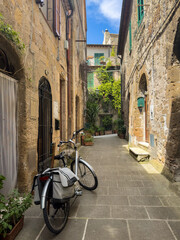 Inviting vintage image of a narrow stone street with a bicycle and greenery. Sustainable travel concept. Ideal for eco-ads