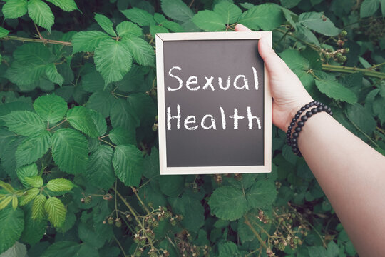 Person holds a chalkboard with the word sexual health written on it