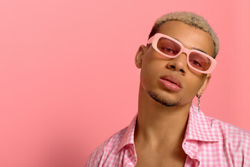 Young african american man showcases stylish look on pink backdrop with confidence