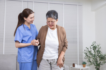Fototapeta premium Healthcare, caregiver, hospitality, senior people, young nurse helping elderly woman with seated stretching activity on the couch, promoting trust, wellness, and positive physical therapy at home