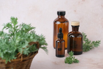 Brown glass bottles filled with essential oils are placed on a soft backdrop, accompanied by a...