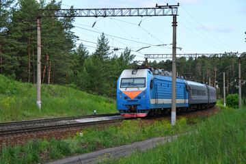 Blue Electric Train on the Railway Track in the forest close up