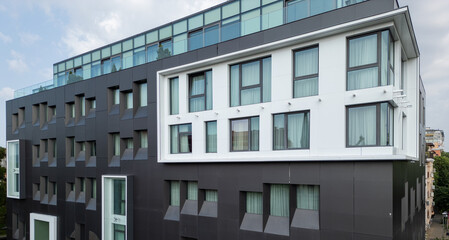 Video of a modern black-and-white building with corner windows and geometric facade. Contemporary urban architecture with clean lines and curtain-covered glass panels