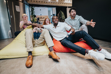 A group of colleagues sits on colorful bean bags, deeply engaged in a video gaming session,...