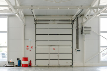 Industrial garage door in modern warehouse interior with fire safety system, HVAC ventilation,...