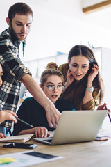 Male student helping amazed women with assignment