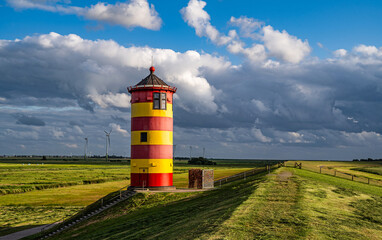 Gewitterwolken über dem Pilsumer Leuchtturm in Ostfriesland, Deutschland