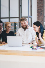 Group of anticipating multiethnic coworkers using laptop at office