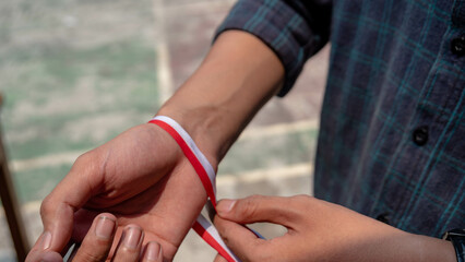 Red and White Ribbon on Fist: Symbol of nationality