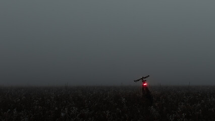 Bicycle in the dark fog on a field.