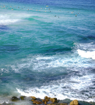 Blue-green sea water with gentle waves and rocks