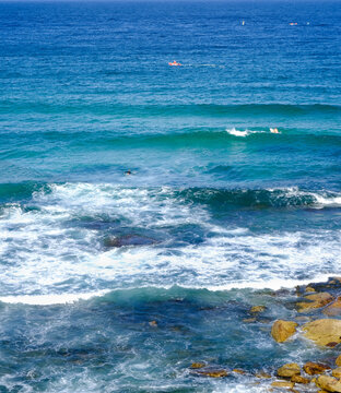 Blue-green sea water with gentle waves and rocks
