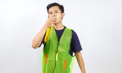 parking attendant wearing green vest blowing whistle loudly