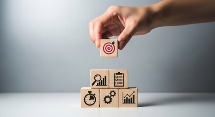 Hand Placing Wooden Block with Target Icon on Top of Stack of Blocks Showing Business Icons Stopwatch Graph
