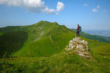Woman with backpack standing on rock. Malá Fatra, Slovakia