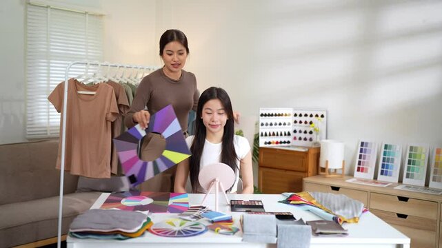 Client seated with purple tone sample board as stylist assists in indoor color evaluation process