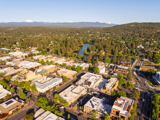 Bend, Oregon, USA, summer morning aerial view of the downtown area, towards the lake and the snow covered volcanoes, Three Sisters and Mount Bachelor