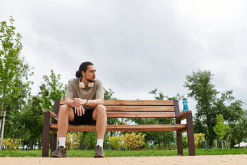 Fototapeta premium Sporty young man enjoying outdoor workout time in a lush green park setting