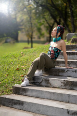 Captivating outdoor portrait of a trendy woman with detailed braids