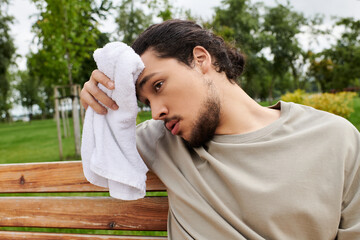 Sporty young man taking a break after an outdoor workout in a serene setting