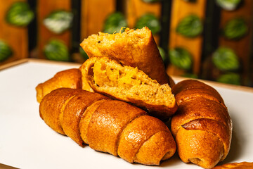 horizontal photo of open empanada with pineapple inside and artisanal whole cheese sticks, sweetened with honey, in a healthy vegetarian restaurant in Colombia