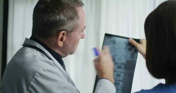 Doctors Reviewing Spine X-Ray for Diagnosis