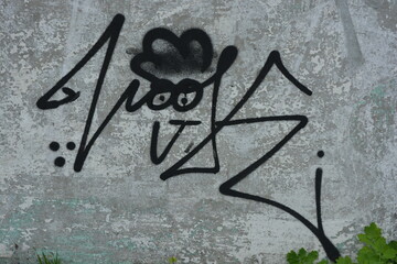 Graffiti, inscriptions on the wall, unusual drawings drawn on an old cement fence, wall. Dashes,...