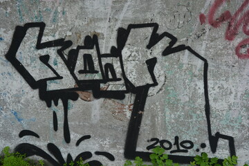 Graffiti, inscriptions on the wall, unusual drawings drawn on an old cement fence, wall. Dashes,...