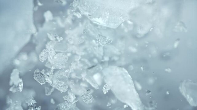 Super Slow Motion Shot of Ice Pieces Flying Towards Camera on Light Cold Background at 1000fps.