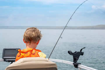 Youth caucasian boy looking out over a body of water while fishing 