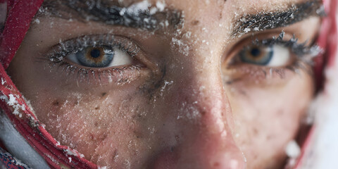 Captivating Gaze in Winter's Embrace: Intimate portrait of a person with icy eyelashes and eyebrows, their striking eyes reflect the serenity and quiet beauty of winter.