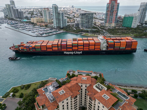 Miami, Florida, USA - January 16, 2025: Bremen express. Freight container on cargo vessel. Cargo ship vessel. Miami port. Container ship. Cargo Hapag Lloyd container ship in dramatic sea, aerial view