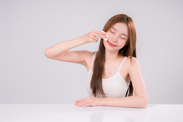 Fototapeta premium Skin Care Woman Asian Person Smile White Beauty Young Portrait Face Background, Confident and Radiant Female Model with Healthy Skin On White Background