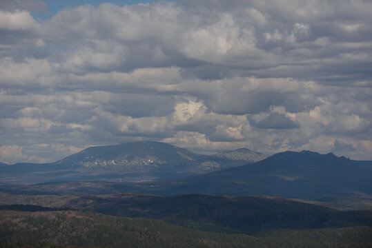 Many cumulus clouds over the hills. Mountain landscape.