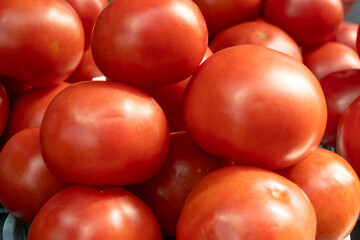 Vibrant red tomatoes symbolizing the essence of life and growth. Fresh tomatoes on display at a bustling market, inviting a taste of summer.