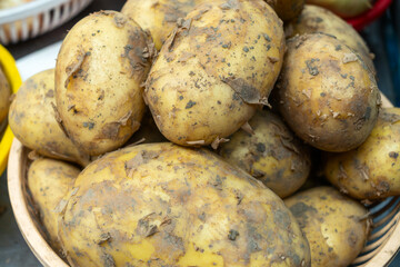 Harvest bounty. Freshly dug potatoes in rustic baskets at the market. A closeup view of organic...