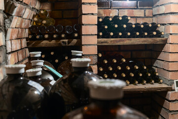 Rustic Wine Cellar Filled With Aging Bottles On Wooden Shelves. A Detailed View Of A Rustic Wine Cellar Filled With Carefully Aged Bottles On Wooden Shelves.