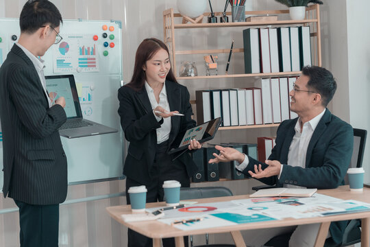 Business team discussing charts and graphs about investment and business growth. Business colleagues analyzing financial data at desk in office. - Powered by Adobe