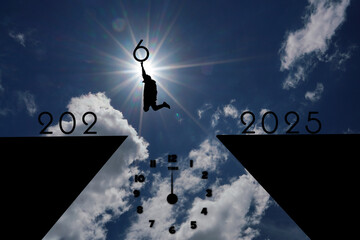silhouette of Man jumping on cliff 2025 to 2026 over the precipice at amazing sunset. New Year's...
