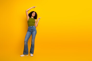 Young smiling woman in casual outfit with curly hair enjoying a cheerful moment against a vibrant...