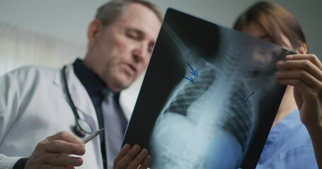 Senior Doctor and Nurse Examining X-Ray Scan - Powered by Adobe