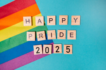 Rainbow flag is on a blue background with the words Happy Pride 2025