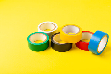 Insulating tape on a bright colored background. Set of different colors insulating tape. Reel...