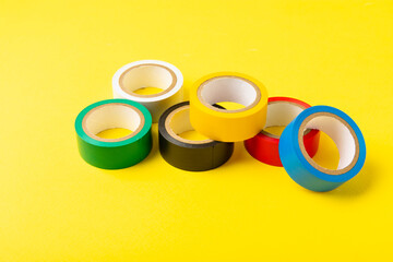 Insulating tape on a bright colored background. Set of different colors insulating tape. Reel...