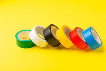 Insulating tape on a bright colored background. Set of different colors insulating tape. Reel...