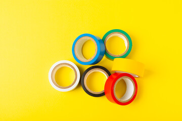Insulating tape on a bright colored background. Set of different colors insulating tape. Reel...