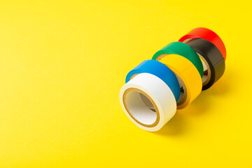 Insulating tape on a bright colored background. Set of different colors insulating tape. Reel...